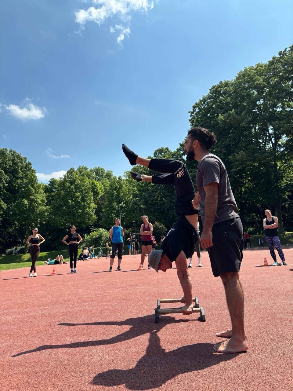Tamer Eskin sichert einen Teilnehmer beim Handstand auf einem Workshop